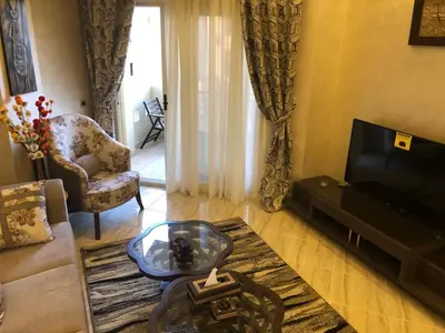 a living room with a couch and a tv at VIVA Andalouse luxury family suite, private beach & pool, NO ORFI in Hurghada