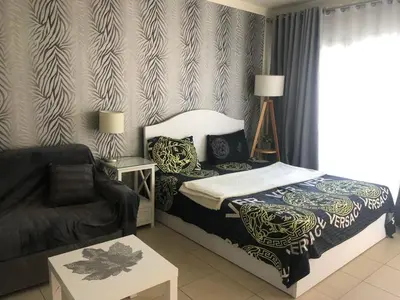 a bedroom with a bed and a couch at Apartman Veranda in Hurghada