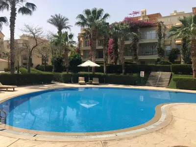 a large blue swimming pool in front of a building at Apartman Veranda in Hurghada