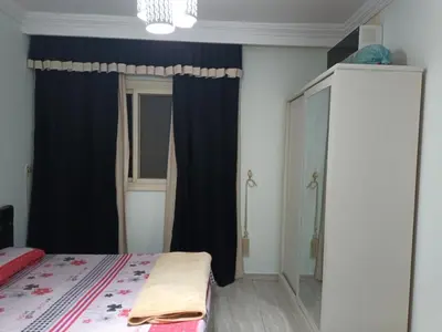 a bedroom with a bed and a blue curtain at sheraton blaza329 in Hurghada