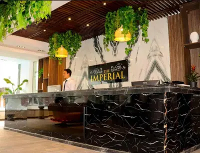 a man standing behind a counter in a hotel lobby at Luxury 95m Penthouse - Boutique Resort & Wifi in Hurghada