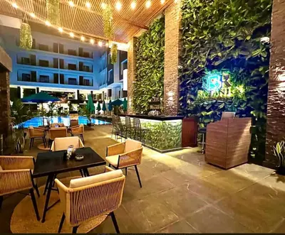 a restaurant with tables and chairs and a wall of plants at Luxury 95m Penthouse - Boutique Resort & Wifi in Hurghada