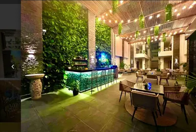 a restaurant with tables and chairs and a green wall at Luxury 95m Penthouse - Boutique Resort & Wifi in Hurghada