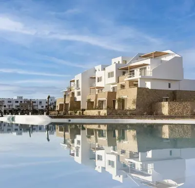 a rendering of a building next to a body of water at EL Gouna Swan Lake Apartment in Hurghada