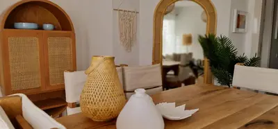 a dining room table with two vases on top of it at EL Gouna Swan Lake Apartment in Hurghada