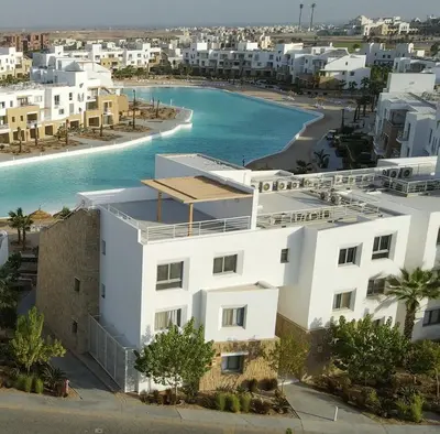 an aerial view of a white building and a beach at EL Gouna Swan Lake Apartment in Hurghada