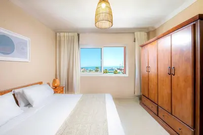 a bedroom with a large bed and a window at AJIRA Bay Hotel Hurghada Marina in Hurghada