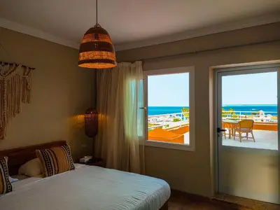 a bedroom with a bed and a view of the ocean at AJIRA Bay Hotel Hurghada Marina in Hurghada