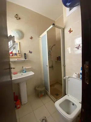 a bathroom with a shower and a sink and a toilet at Чудесная студия в комплексе с бассейном рядом с бесплатным пляжем in Hurghada