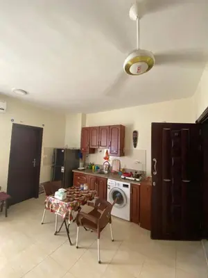 a kitchen with a table and a stove and a dishwasher at Чудесная студия в комплексе с бассейном рядом с бесплатным пляжем in Hurghada