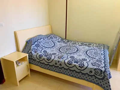 a small bed with a blue and white blanket on it at Прекрасная студия в комплексе с бассейном рядом с бесплатным пляжем in Hurghada