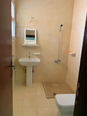 a bathroom with a sink and a toilet and a computer monitor at Прекрасная студия в комплексе с бассейном рядом с бесплатным пляжем in Hurghada