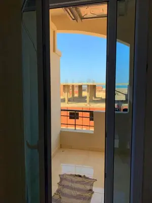 a sliding glass door with a view of a balcony at Прекрасная студия в комплексе с бассейном рядом с бесплатным пляжем in Hurghada