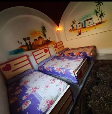two beds sitting next to each other in a room at Aziza House in Aswan