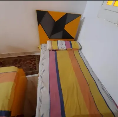 a bed with a colorful comforter in a room at Aziza House in Aswan