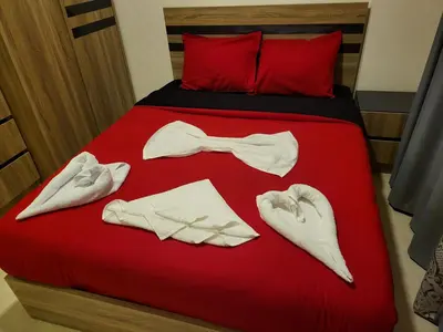 a bed with a red bedspread with a bow tie and clothes at Central location Aqua Tropical Resort Al Gouna RD 401 in Hurghada