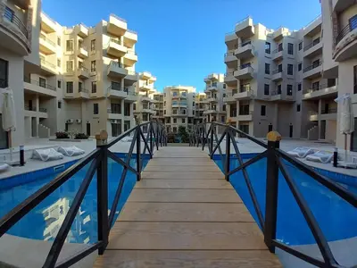 a bridge over a swimming pool in front of apartment buildings at Central location Aqua Tropical Resort Al Gouna RD 401 in Hurghada