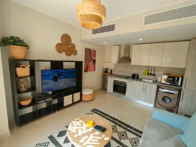 a living room with a television and a kitchen at Mangroovy Gouna 1 BR apartment in Hurghada