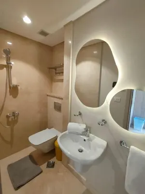 a bathroom with a sink and a toilet and a mirror at Mangroovy Gouna 1 BR apartment in Hurghada