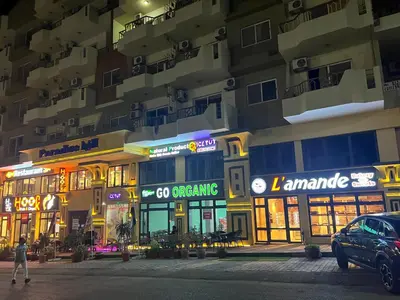 a man walking in front of a building at night at Paradise Hill Compound in Hurghada