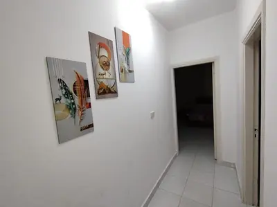 a hallway with four pictures on a white wall at Paradise Hill Compound in Hurghada