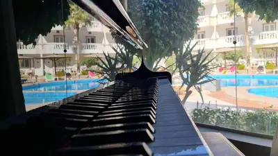 a piano in front of a pool with a building at Zak Inn in Hurghada