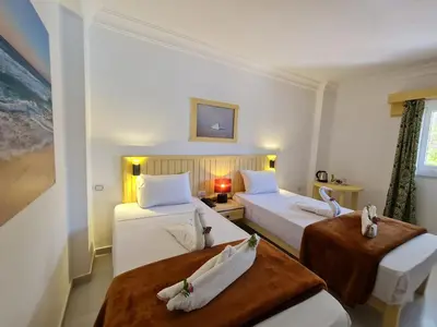 a hotel room with two beds and a window at Zak Inn in Hurghada