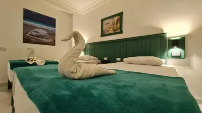 a swan sitting on a bed in a bedroom at Zak Inn in Hurghada