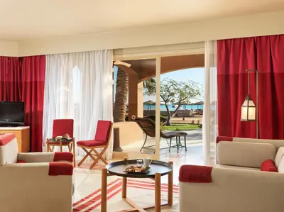 a living room with red curtains and a table at Club Paradisio El Gouna Red Sea in Hurghada