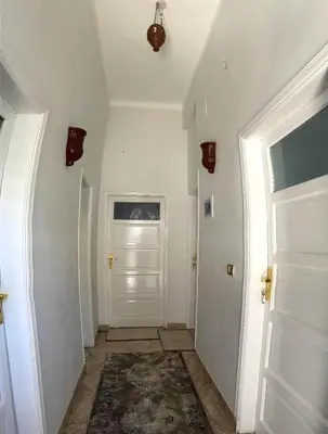a hallway with white walls and a white door at Luxor Oasis Guest House in Luxor