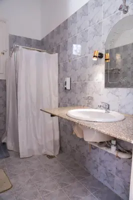 a bathroom with a sink and a shower curtain at Luxor Oasis Guest House in Luxor