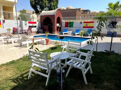 a white table and chairs next to a pool at Luxor Oasis Guest House in Luxor