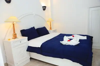 a bedroom with a blue bed with towels on it at Luxor Oasis Guest House in Luxor