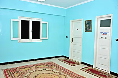 a blue room with two windows and a door at Fontana Hostel luxor in Luxor