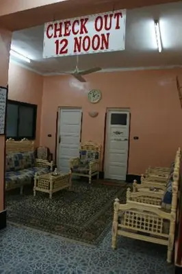 a room with chairs and a sign that reads check out moon at Fontana Hostel luxor in Luxor