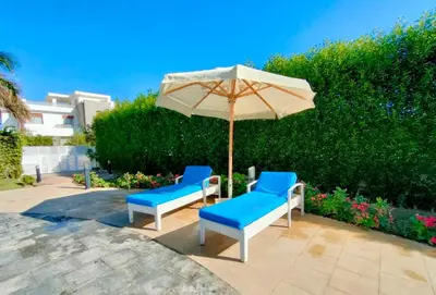 two blue chairs and an umbrella on a patio at Luxury 8BR Villa with seaview and private pool in Hurghada in Hurghada