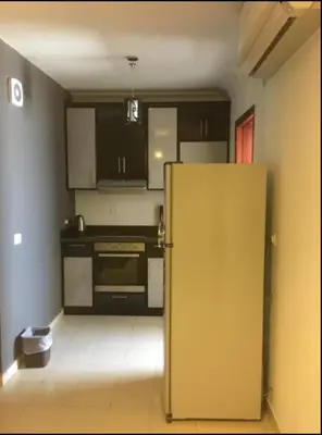 a kitchen with a refrigerator in the middle of a room at Pool view one bedroom - B203 in Hurghada