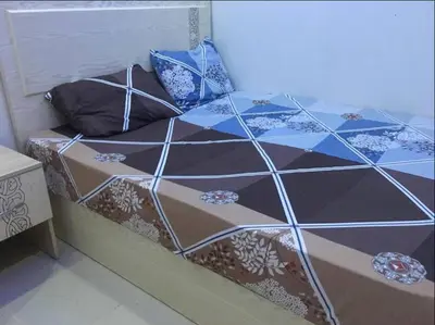 a bed with a comforter and pillows on it at Pool view one bedroom - B203 in Hurghada