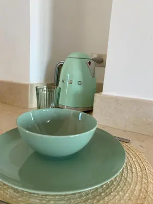 a bowl on a plate next to a tea kettle at Sabina 2br penthouse in Hurghada