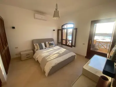 a bedroom with a large bed and a window at Sabina 2br penthouse in Hurghada