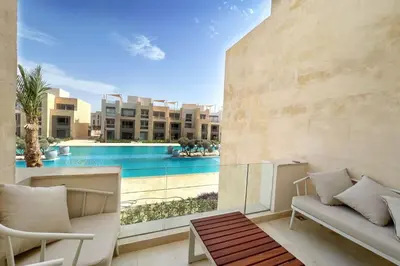 a living room with a view of a swimming pool at Boho Mint 1 BDR Mangroovy Pool & Sea View in Hurghada