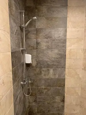 a shower in a bathroom with a stone wall at La Casa Beach in Hurghada