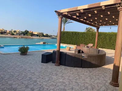 a pavilion with a table and chairs next to a pool at 3Bedrooms Villa with Private Pool and direct Lagoon Access in Hurghada