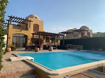 a swimming pool in front of a house at 3Bedrooms Villa with Private Pool and direct Lagoon Access in Hurghada