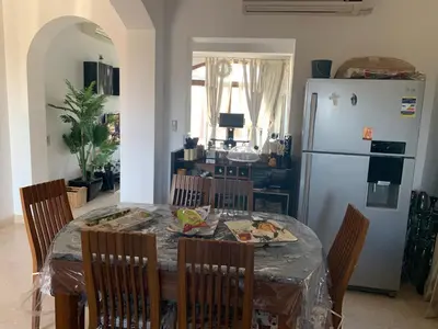 a kitchen with a table with chairs and a refrigerator at 3Bedrooms Villa with Private Pool and direct Lagoon Access in Hurghada