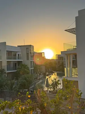 a sunset view from the balcony of a resort at Lovely 1 Bedroom apt. At Mangroovy residence with free access to the Beach and Pools in Hurghada