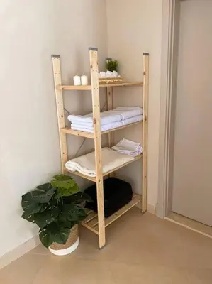 a wooden shelf with towels and a plant in a room at Lovely 1 Bedroom apt. At Mangroovy residence with free access to the Beach and Pools in Hurghada