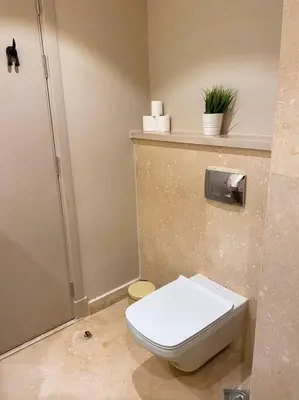 a bathroom with a white toilet and a shower at Lovely 1 Bedroom apt. At Mangroovy residence with free access to the Beach and Pools in Hurghada