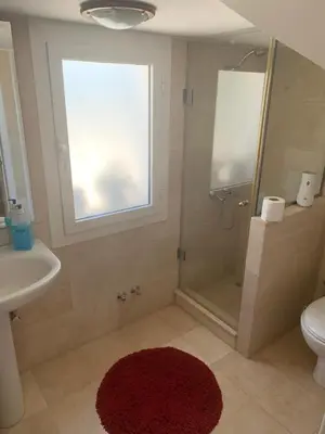 a bathroom with a shower and a toilet and a sink at Snow White Villa in Hurghada