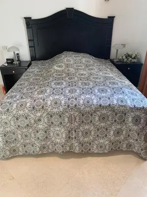 a bed with a comforter on top of it at Snow White Villa in Hurghada